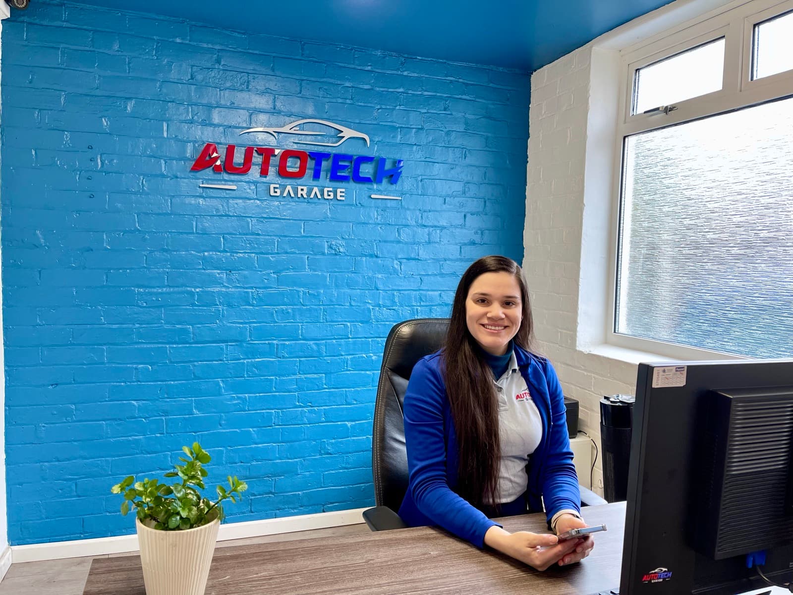 A member of the team at the reception desk in the AutoTech office.